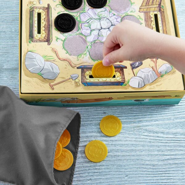 une main d'enfant met une pièce d'or dans la boite du jeu à l'endroit prévu