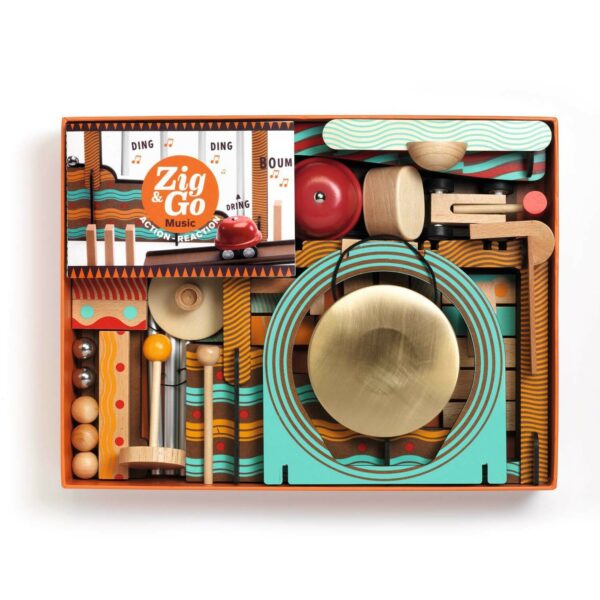 intérieur de la boite du jeu Zig & Go Music avec une clochette des dominos des billes en métal et en bois des rampes un gong et d'autres accessoires