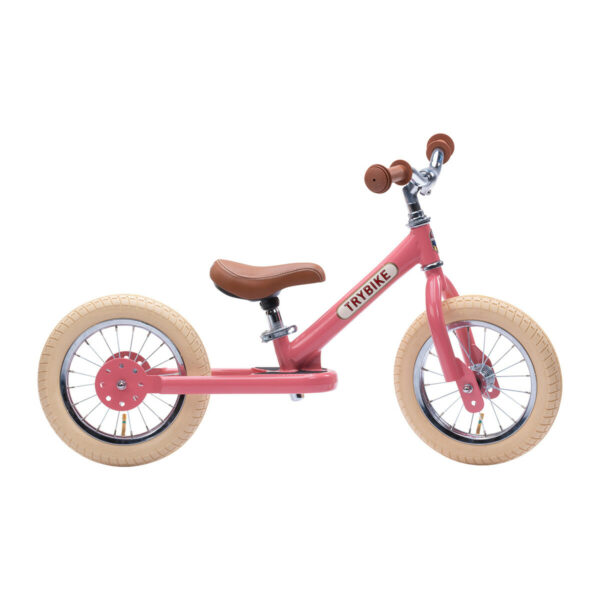Cette belle draisienne rose est un vélo sans pédales qui va initier l'enfant au vélo.