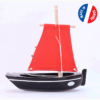 Le Bateau Noir en bois voile rouge le Misainier est un canot de 22 cm, idéal pour la plage ou pour le bain.