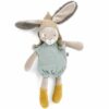 peluche petit lapin est toute douce et est vêtu d'une barboteuse de couleur sauge et d'un petit bonne