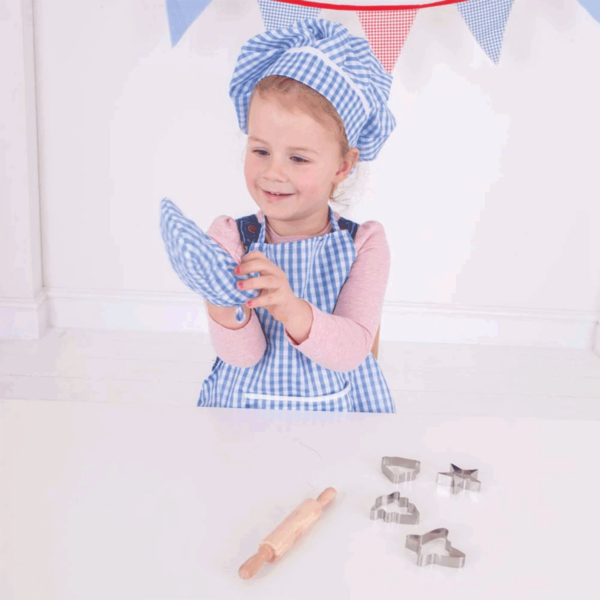 La panoplie se compose d'une toque, d'une manique, d'un tablier en vichy bleu, d'un rouleau à pâtisserie et de 4  emporte-pièces pour faire des gâteaux.