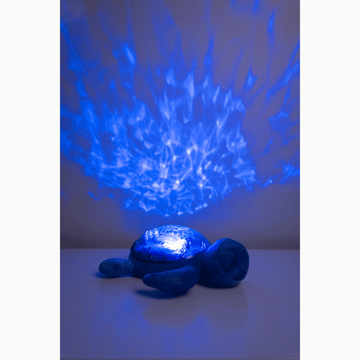 Veilleuse tortue musicale bleue Cette veilleuse peluche diffuse une douce lumière et projette sur le plafond de la chambre les vagues de l’océan en mouvement