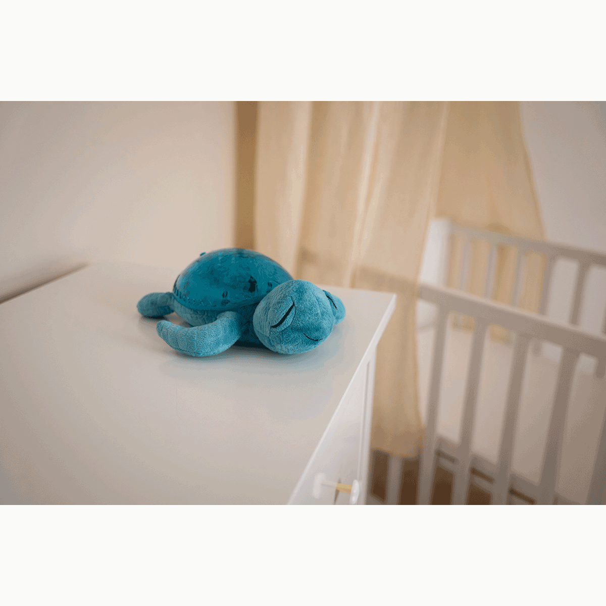 Veilleuse tortue musicale bleue Douce peluche la journée, elle se transforme en veilleuse la nuit venue. Son effet de lumière sous-marine est magique, grâce aux projections de vagues en mouvements.